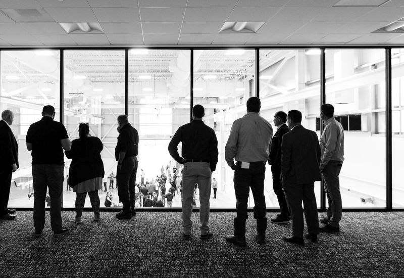 People standing in front of a window with more people below.