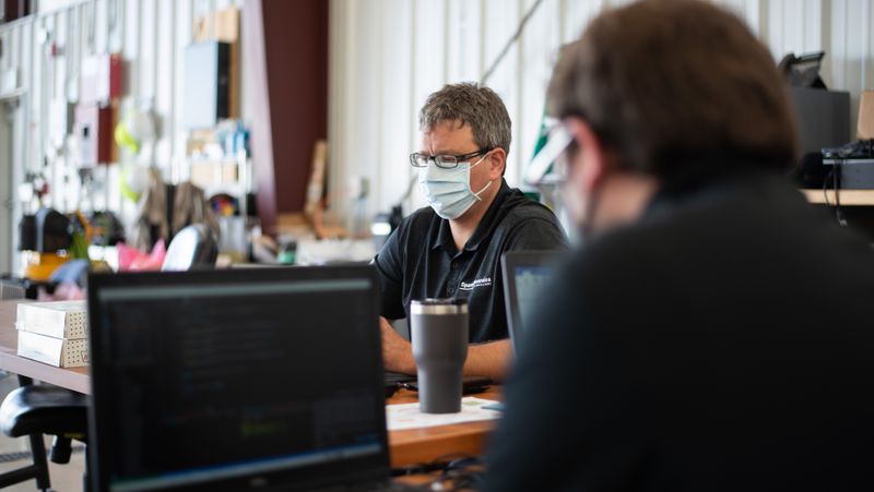 Masked staff working in the hangar.