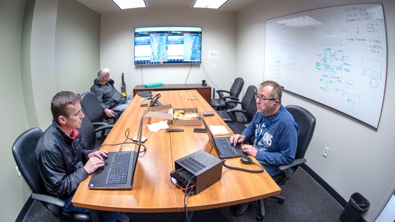 Engineers work on flight modeling in a conference room.