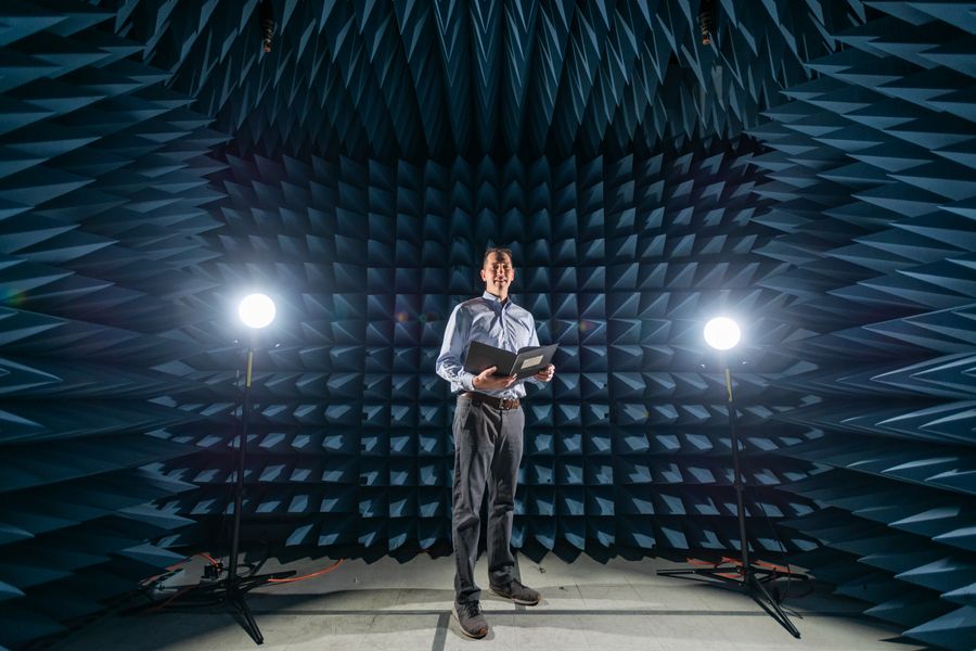 A person standing inside an anechoic EMI chamber.