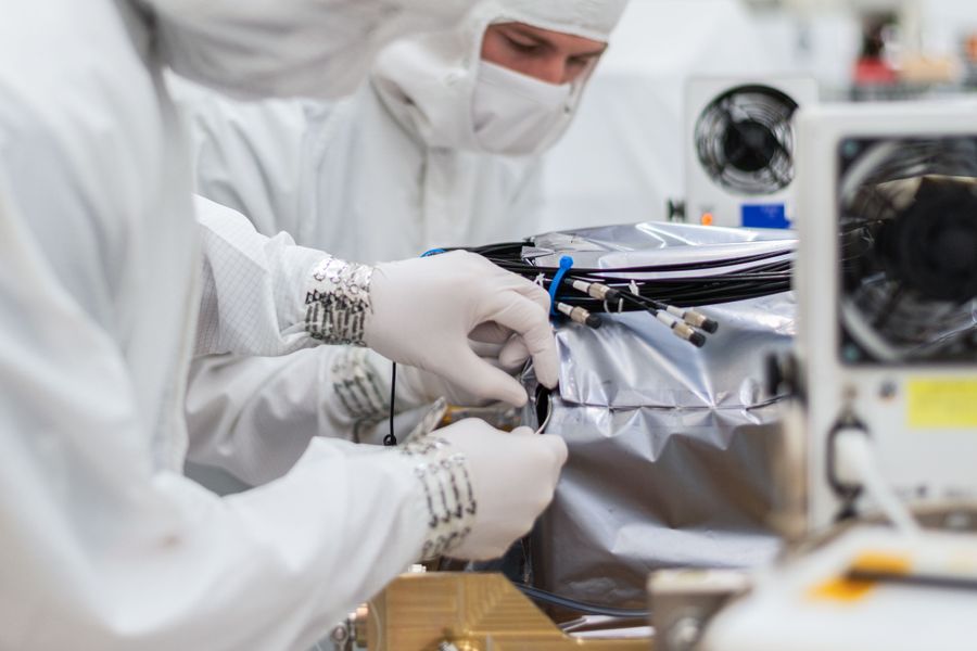 Staff working on hardware in an assembly laboratory.