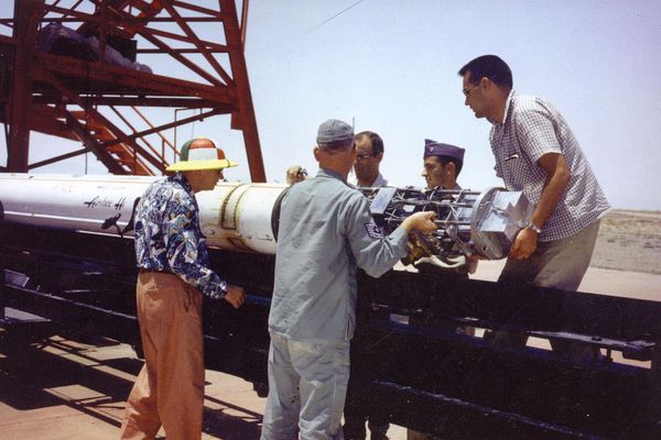 An image from the 1960s of staff lifting the back end of a sounding rocket.