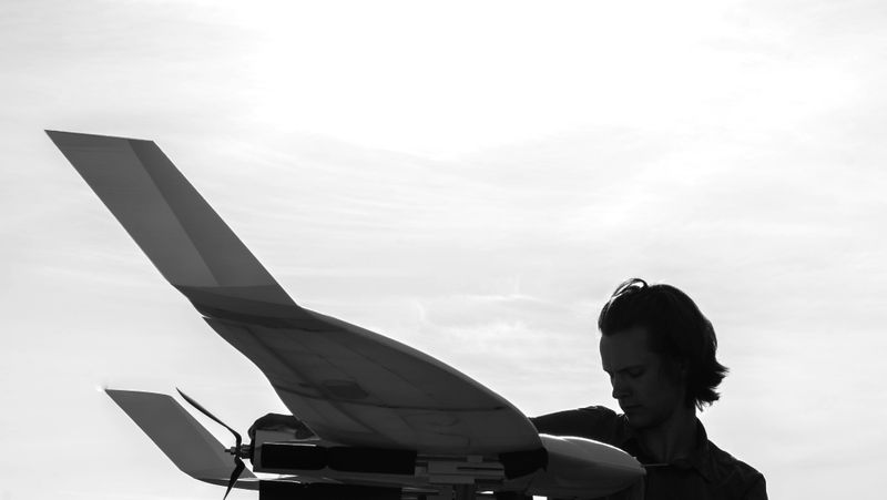 Silhouette of a person holding a UAS.