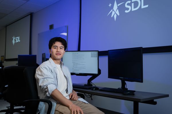 An SDL Intern sitting in an SDL training room.