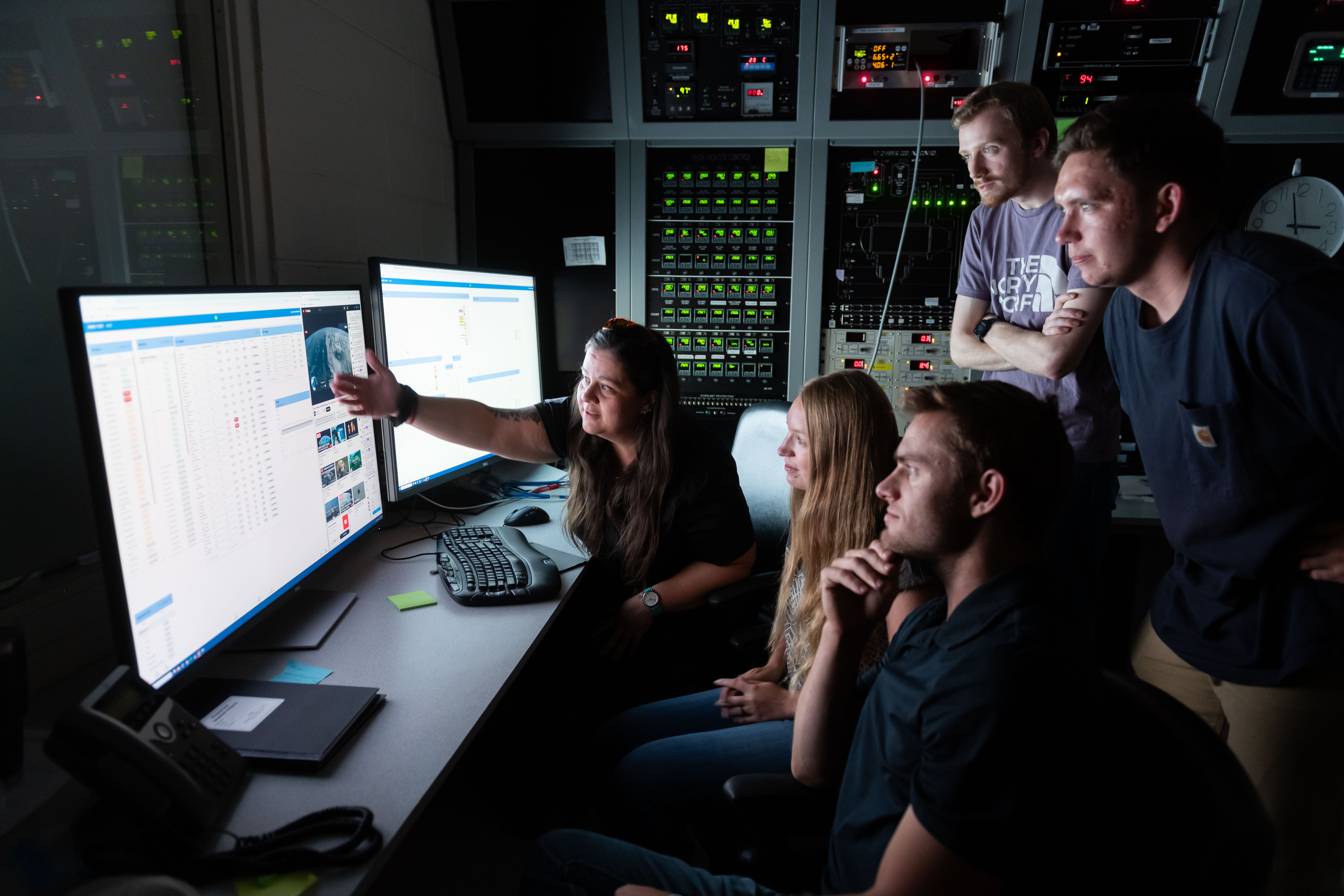 SDL's Brittany Woytko with students examining a computer.