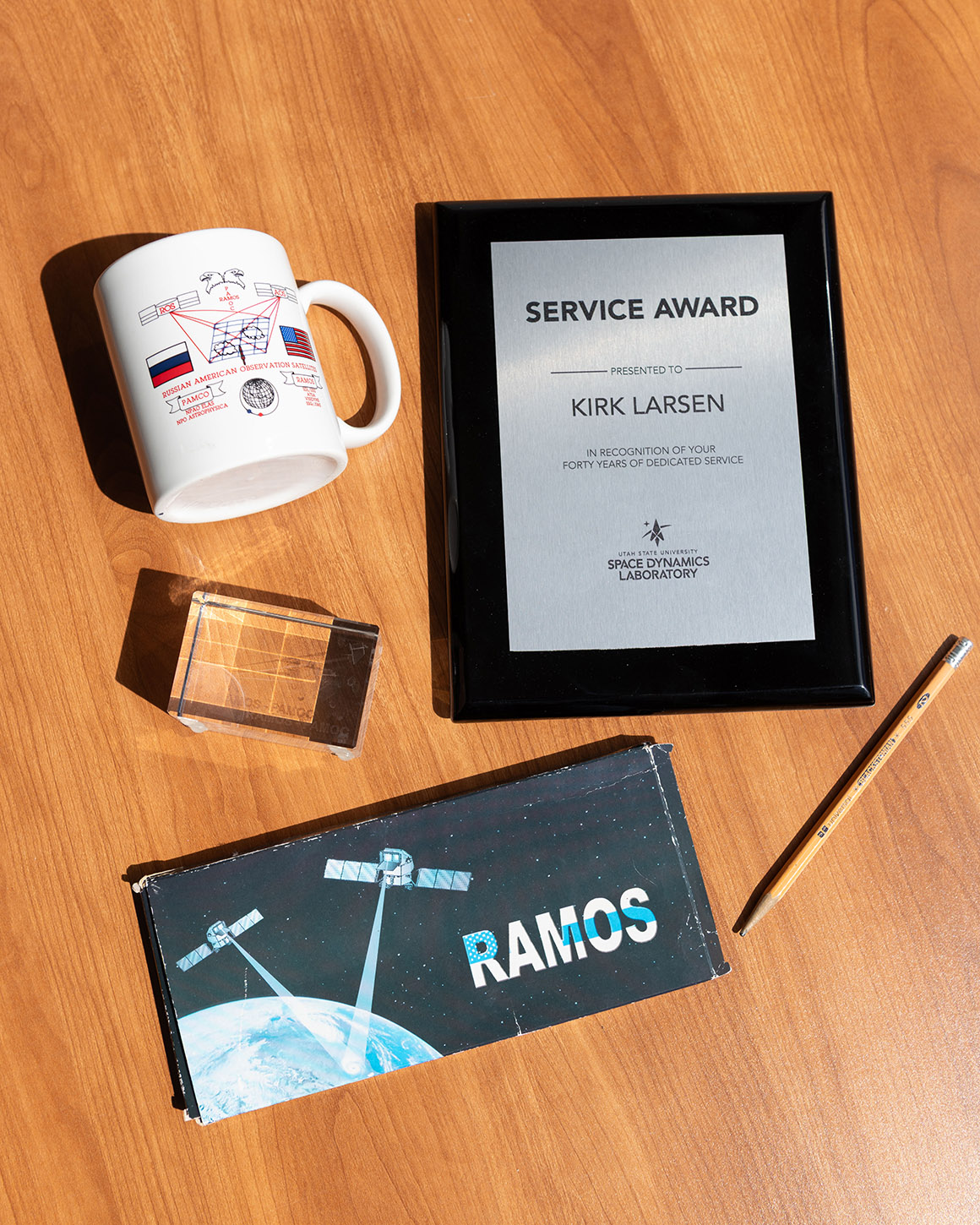 A 40 years of dedicated service award plaque surrounded by mission memorabilia.